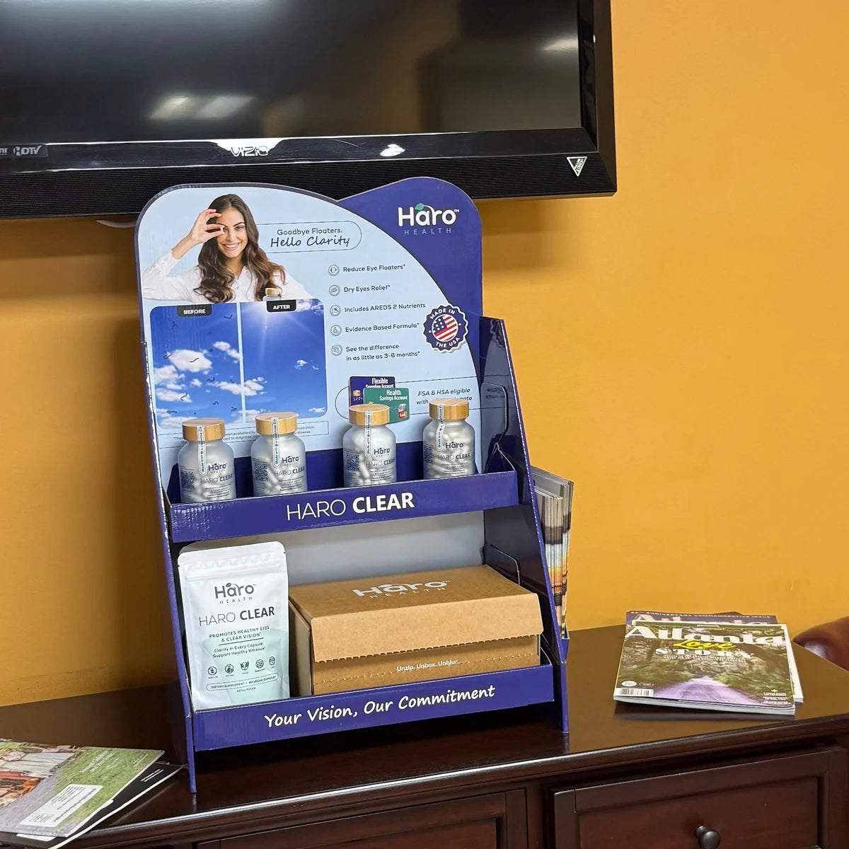 Haro Clear countertop display with bottles, a refill pouch, and a Starter Kit in an eye-care clinic waiting area
